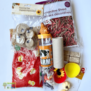 Farm animal sensory bin materials featuring plastic farm animals, corn kernels, sunflowers, shredded paper, and small toys for hands-on sensory play.