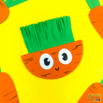 A colorful paper craft of a rocking carrot made from orange and green construction paper, featuring a happy face with large, cartoonish eyes. The carrot's leafy top is made of fringed green paper, and the background is bright yellow. Surrounding the main carrot are partial views of similar rocking carrot crafts.